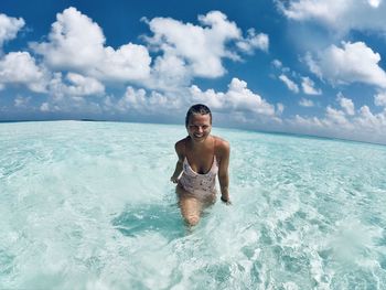 Portrait of smiling woman in sea against sky