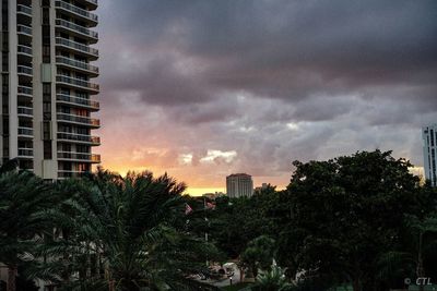 Modern buildings against sky during sunset