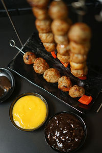 High angle view of grilled meatballs with cheese sauce served on table