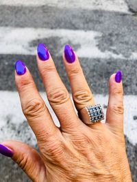 Cropped hand of woman against zebra crossing