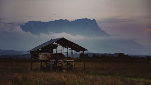 Built structure on field against sky during sunset