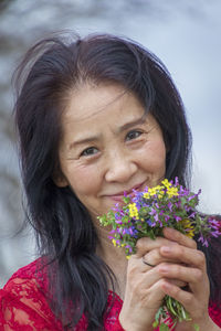 Portrait of a smiling young woman holding flowering plants