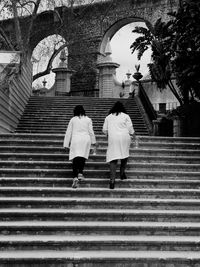 Low angle view of female scientists on staircase leading towards laboratory