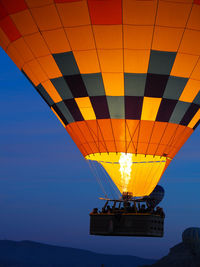 Hot air balloon flying against sky at sunset