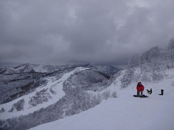 People on snowcapped mountain against sky