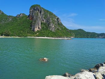 Scenic view of rocks in sea against blue sky