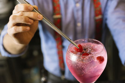 Midsection of bartender making drink