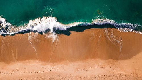 High angle view of surf on sea shore