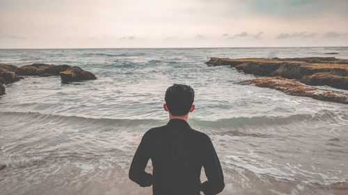 Rear view of man standing on beach