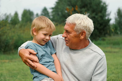 Side view of senior couple sitting on field