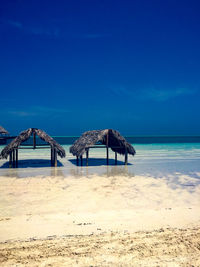 Scenic view of beach against blue sky