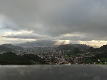 Aerial view of cityscape against dramatic sky