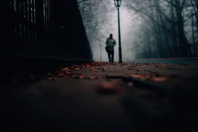 Surface level of man walking on footpath during foggy weather