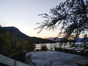 Scenic view of lake against clear sky at sunset