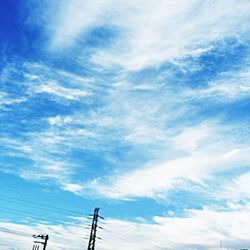 Low angle view of electricity pylon against cloudy sky