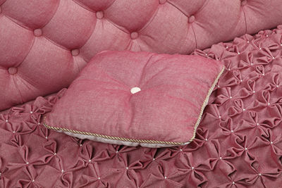 Close-up of cushion on pink sofa