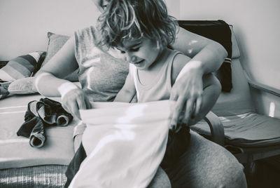 Girl sitting with mother at home