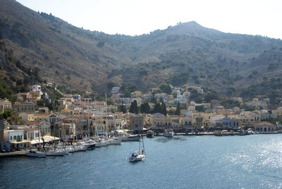 Sailboats in sea with city in background