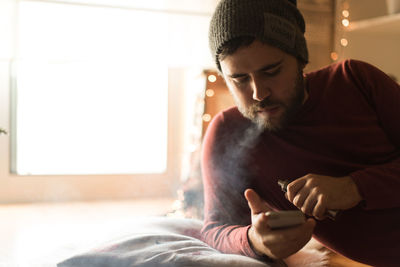 Young man using mobile phone at home