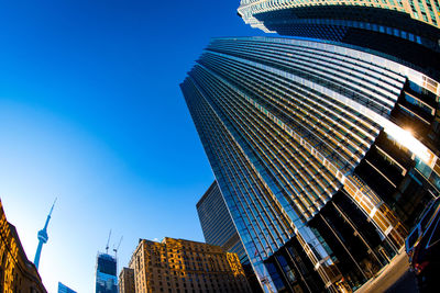 Low angle view of modern buildings against blue sky