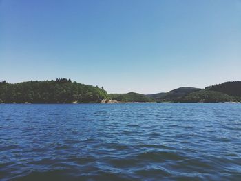 Scenic view of lake against clear blue sky