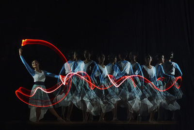 Blurred motion of young woman dancing on stage