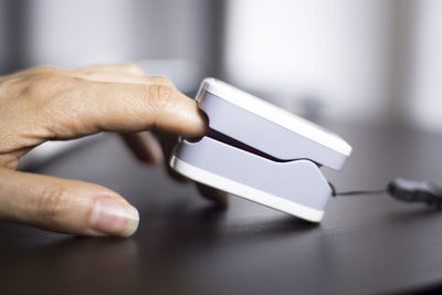 Cropped hand of person taking pulse on table