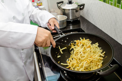 Midsection of man preparing food in kitchen