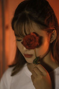 Close-up portrait of a girl holding flower