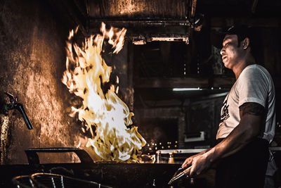 Man standing by fire in restaurant