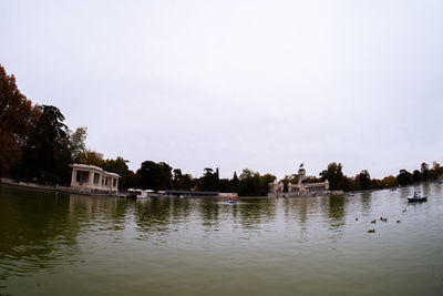 Scenic view of lake by buildings against sky