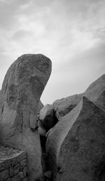 View of rock formation against cloudy sky