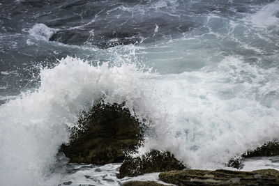 Close-up of waves splashing in sea against sky