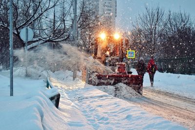 Snow covered road in city at night