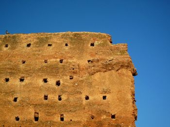 Low angle view of built structure against clear blue sky