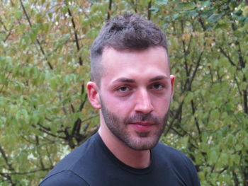 Portrait of young man against trees