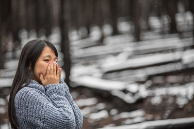 Young woman covering mouth