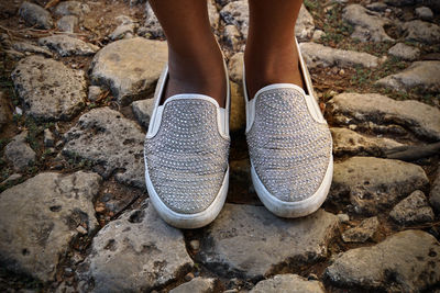 Low section of woman standing on rock