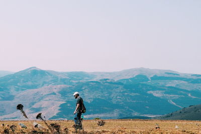 Man walking on land against mountains