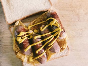 Close-up of hot dogs with mustard on bread slice
