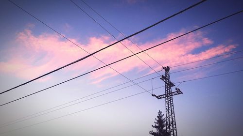 Low angle view silhouette of electricity pylon against sky during sunset