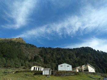 Houses and trees on mountain against sky