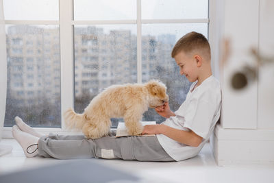 Portrait of boy playing with dog