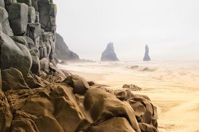 Rocks on beach against clear sky