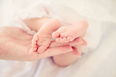 Close-up of baby hand on bed