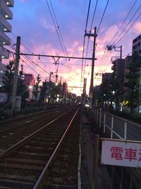 Railway tracks against sky at sunset