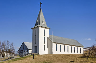 Church on a grassy hill under a blue sky