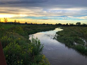 Scenic view of river against sky during sunset