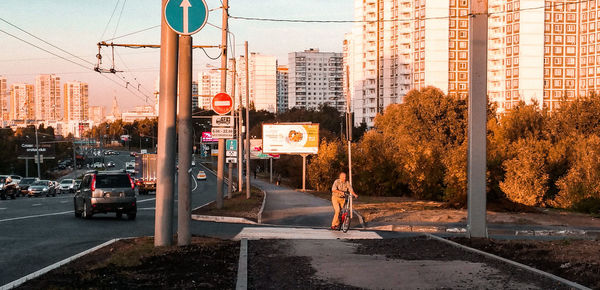 People on street against buildings in city