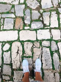 Low section of woman standing on footpath